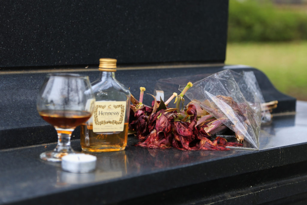 A bottle of Hennesy and a glass of cognac at Maynard Jackson's grave at Oakland Cemetery. Photo by Laura Mercer