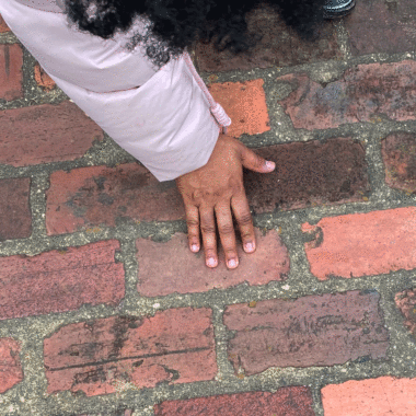 Abra Lee touches the bricks at Oakland Cemetery