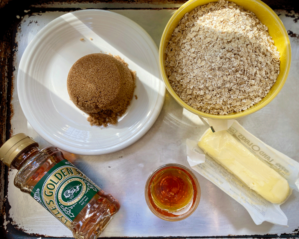 Ingredients for British flapjacks with Lyle's golden syrup, oatmeal, sugar and butter on a tray
