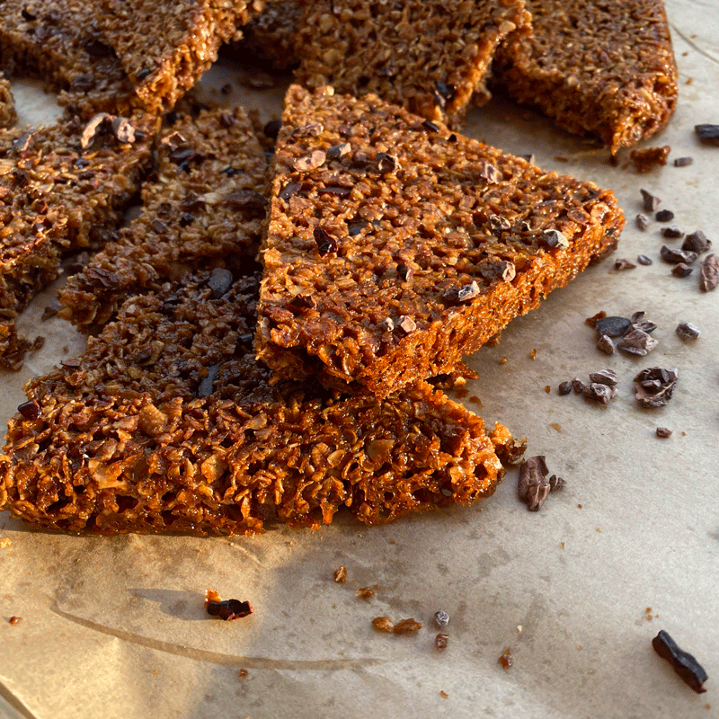 Golden brown British flapjacks cookies with cocoa nibs on a baking sheet