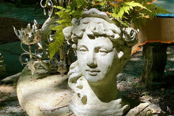 Bust with plants on a table in a garden
