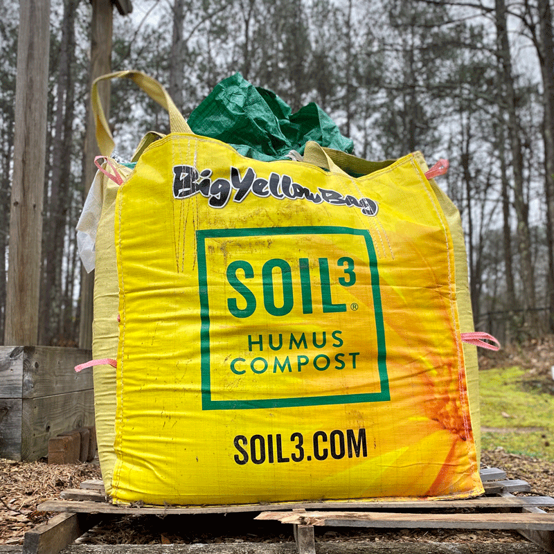Yellow bag of soil in a garden
