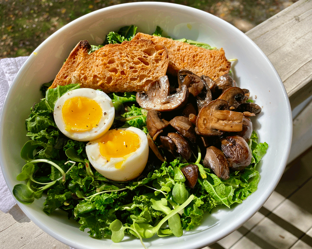 Green salad with croutons, mushrooms and a cooked egg