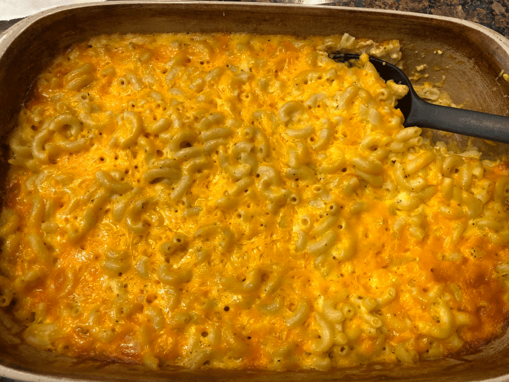A spoon in a dish of baked macaroni and cheese