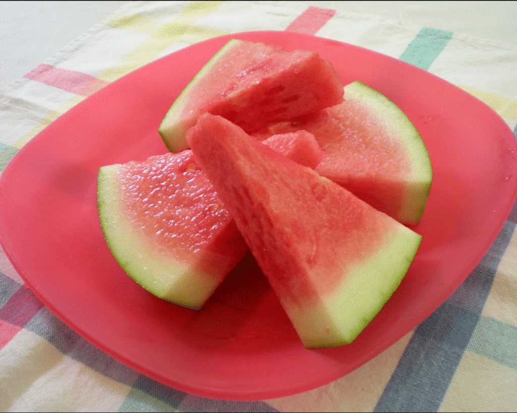 Slices of ripe red watermelon on a red plate