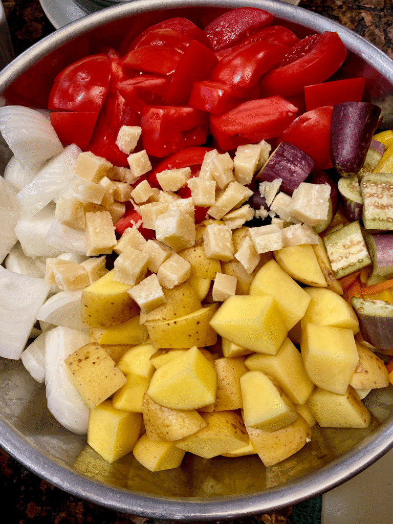 Chopped tomatoes, onions, potatoes and eggplant in a bowl