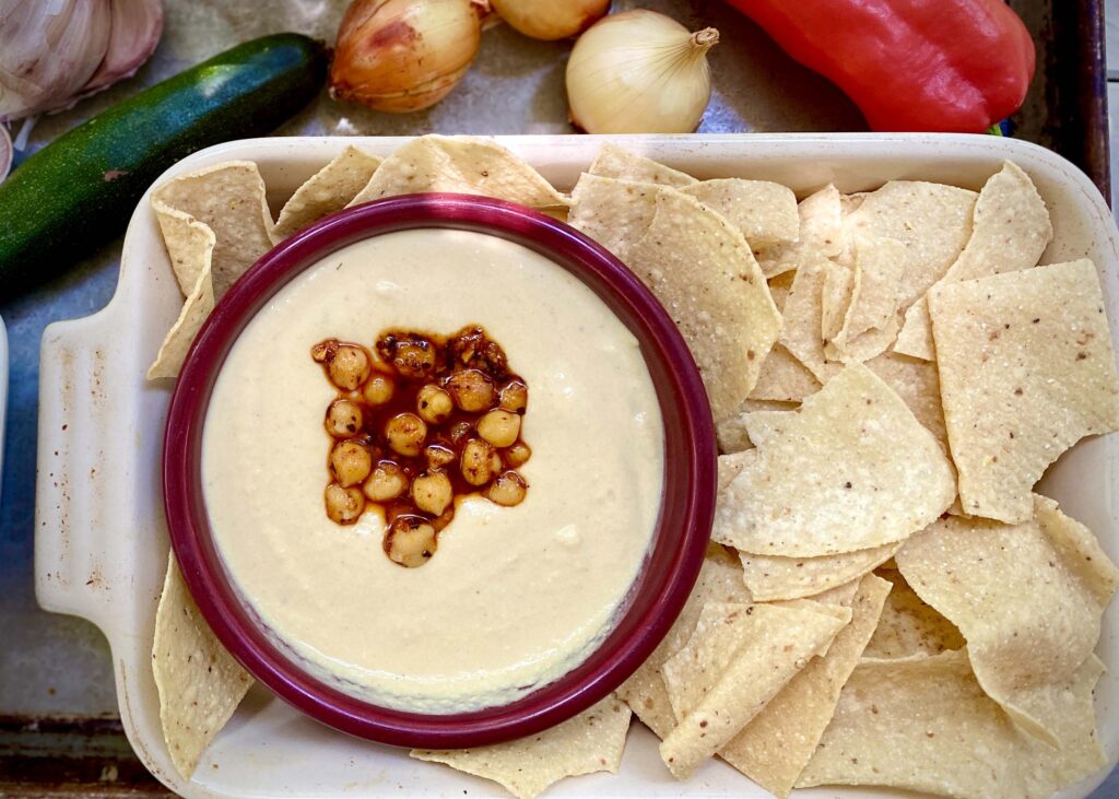 Hummus in a bow surrounded by tortilla chips