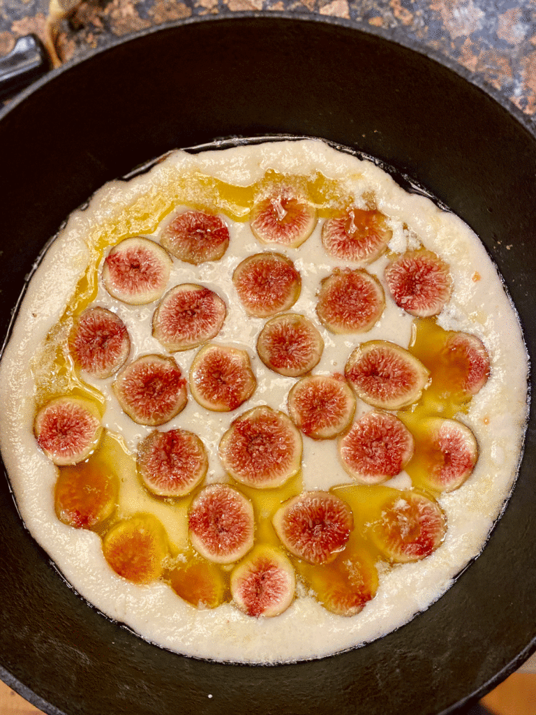 Figs arranged on batter in a cast iron skillet