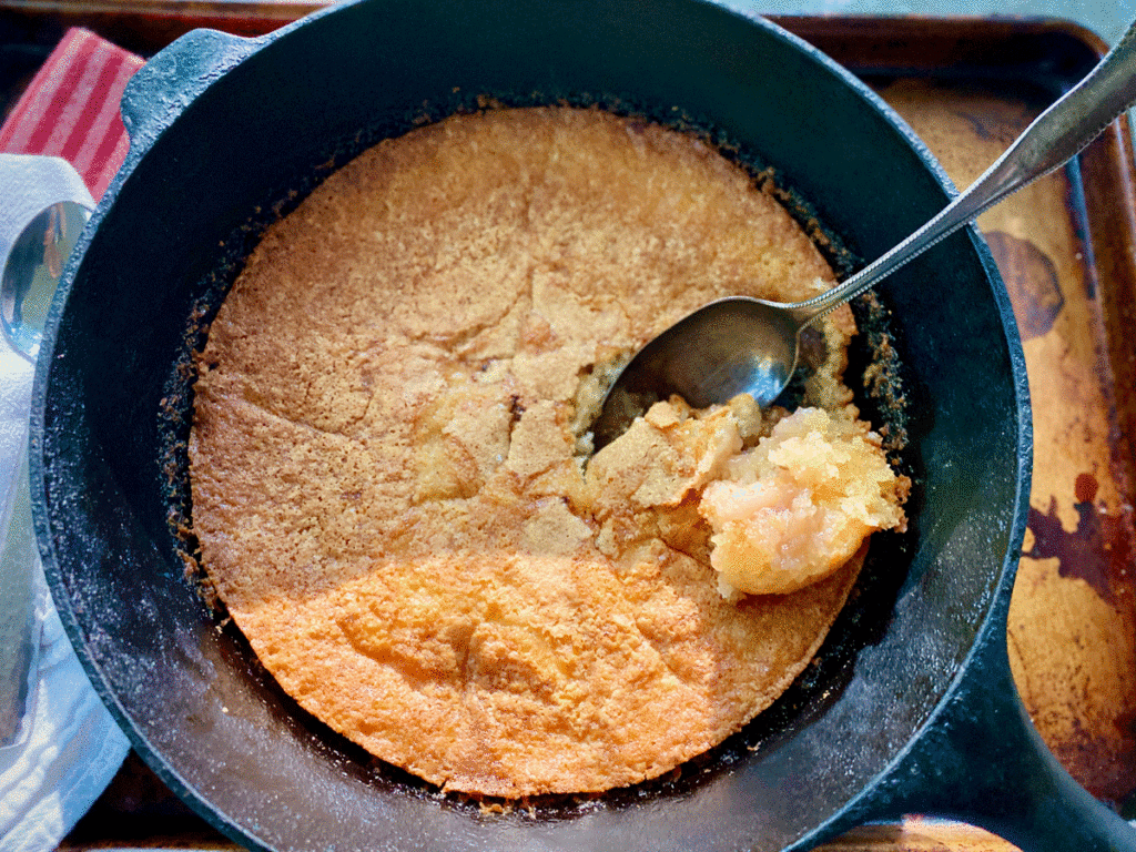 Cast iron skillet with fig cake and a spoon