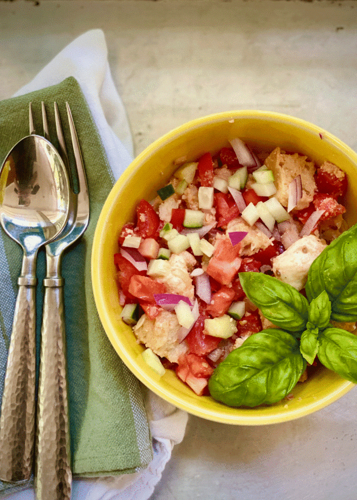 Tomato and bread salad in a bowl with fresh basil