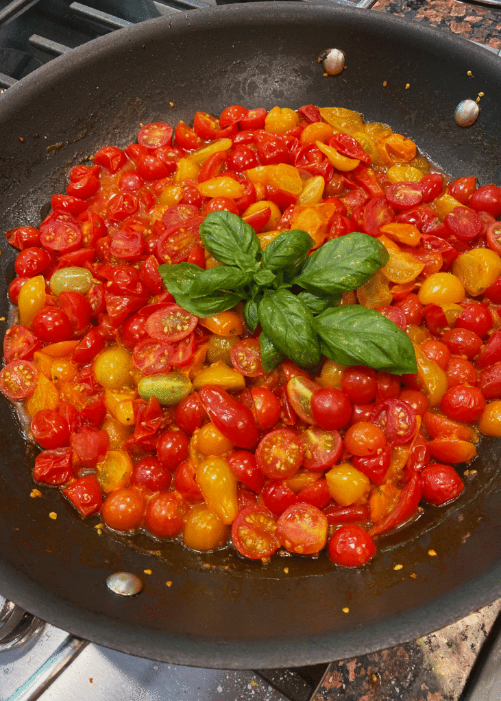 Sauteed cherry tomatoes with basil in a skillet