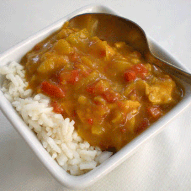 Mulligatawny soup in a white bowl with rice