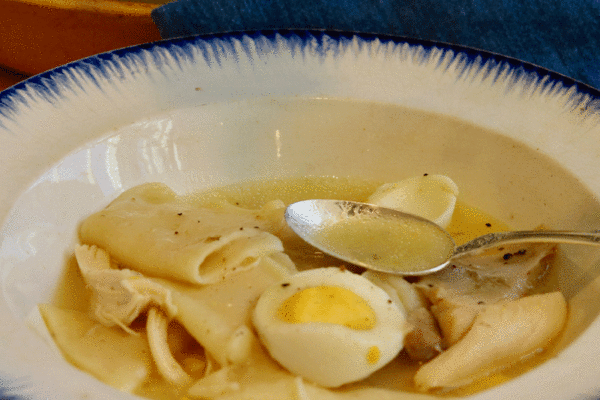 Chicken and dumplings in a bowl with a spoon