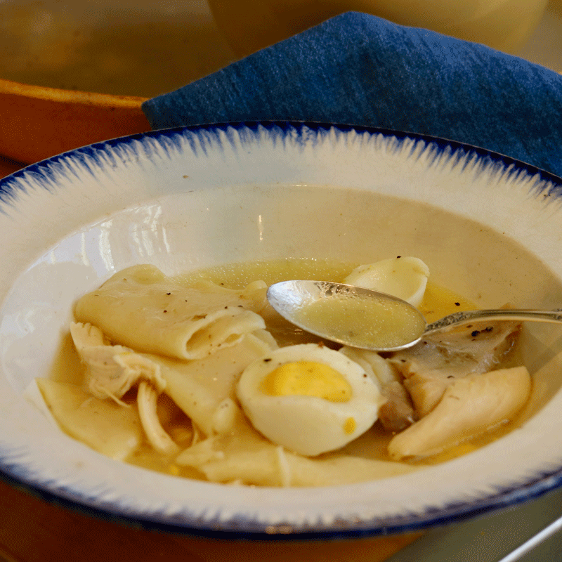 Chicken and dumplings in a bowl with a spoon