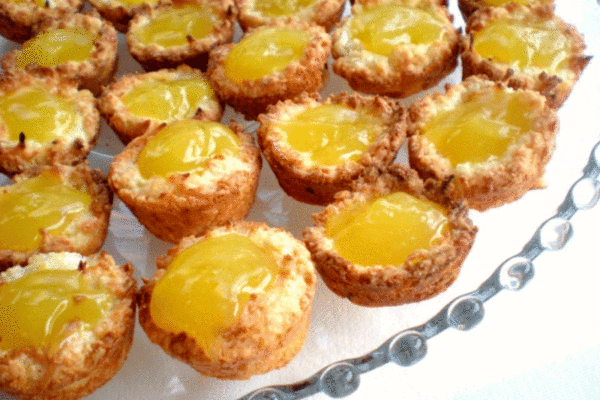 Lemon macaroon tarts on a glass tray