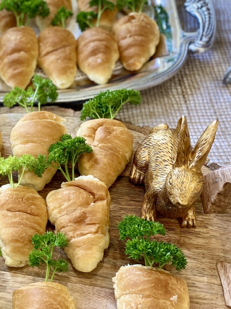 Chicken salad stuffed croissants resembling carrots on a spring themed refreshments table