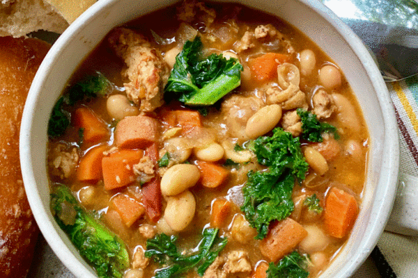 Bowl of vegetable soup with bread and a spoon