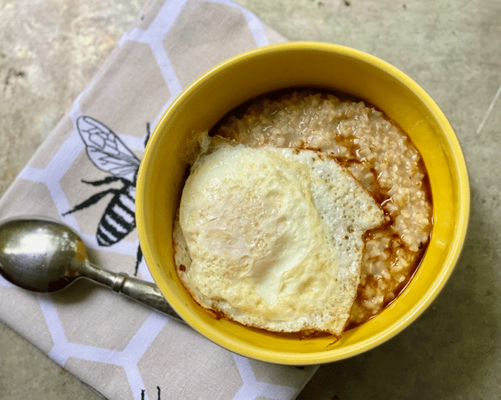 Oatmeal with a cooked egg in yellow bowl