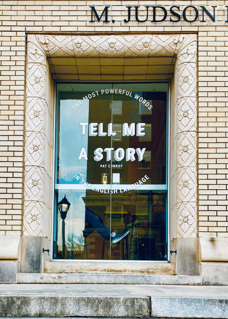 Window with "Tell me a story" at M Judson Booksellers in Greenville, South Carolina