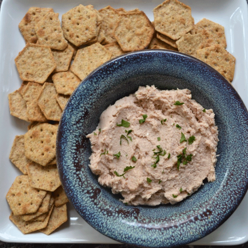 Smoked fish dip in a bowl on platter with crackers