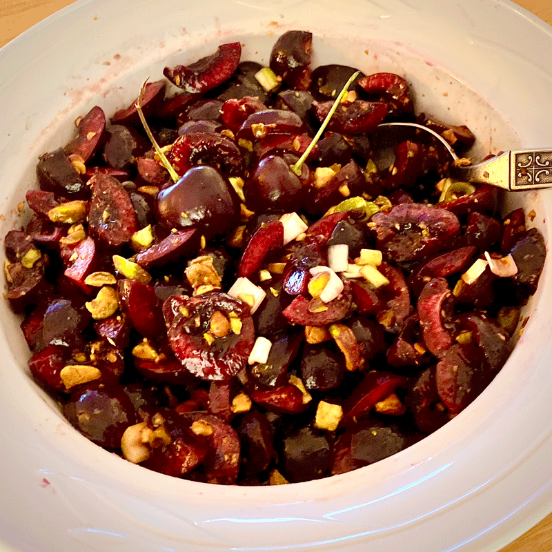Bowl of cherry pistachio salad with a spoon