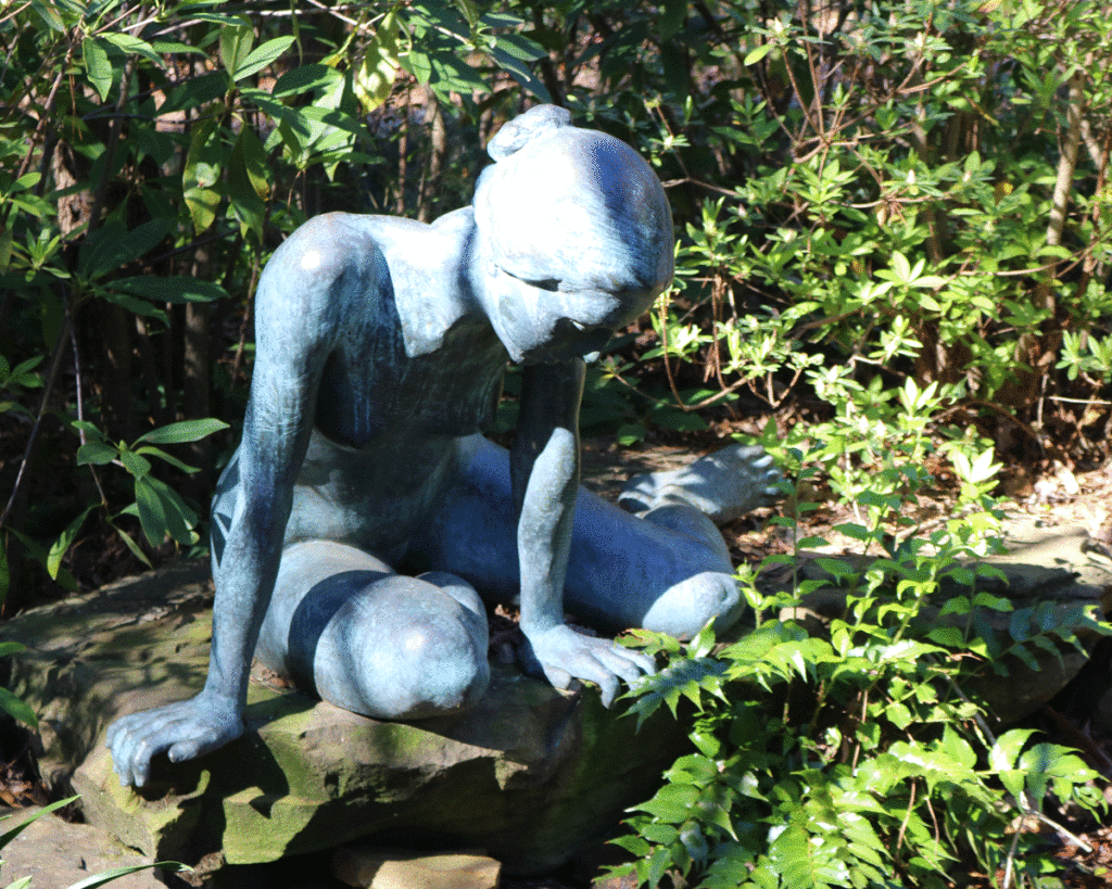 Statue of a female gazing into a pond at the Birmingham Botanical Garden
