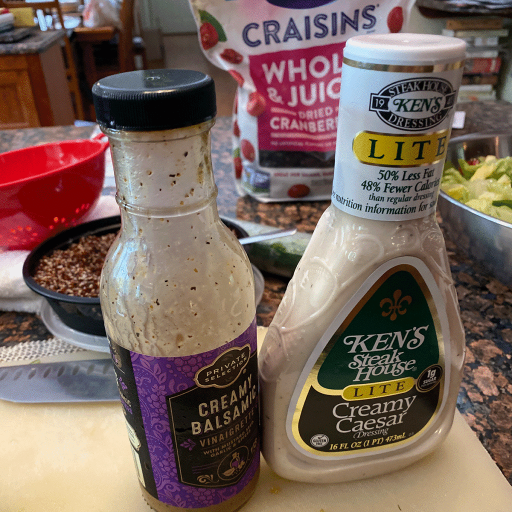 Bottles of Balsamic dressing and Caesar dressing on a kitchen counter