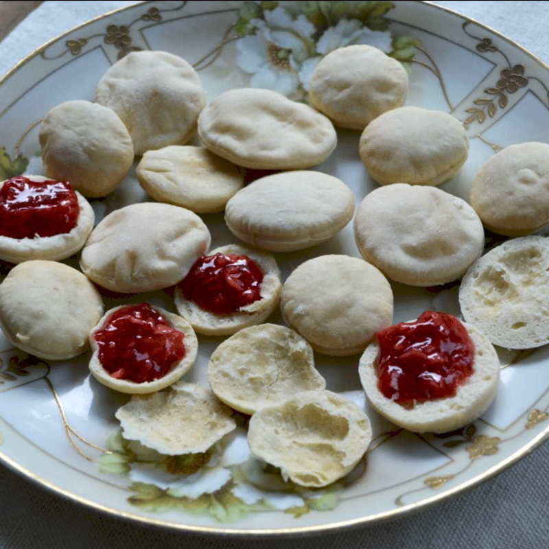 A plate with beaten biscuits, split and filled with jam
