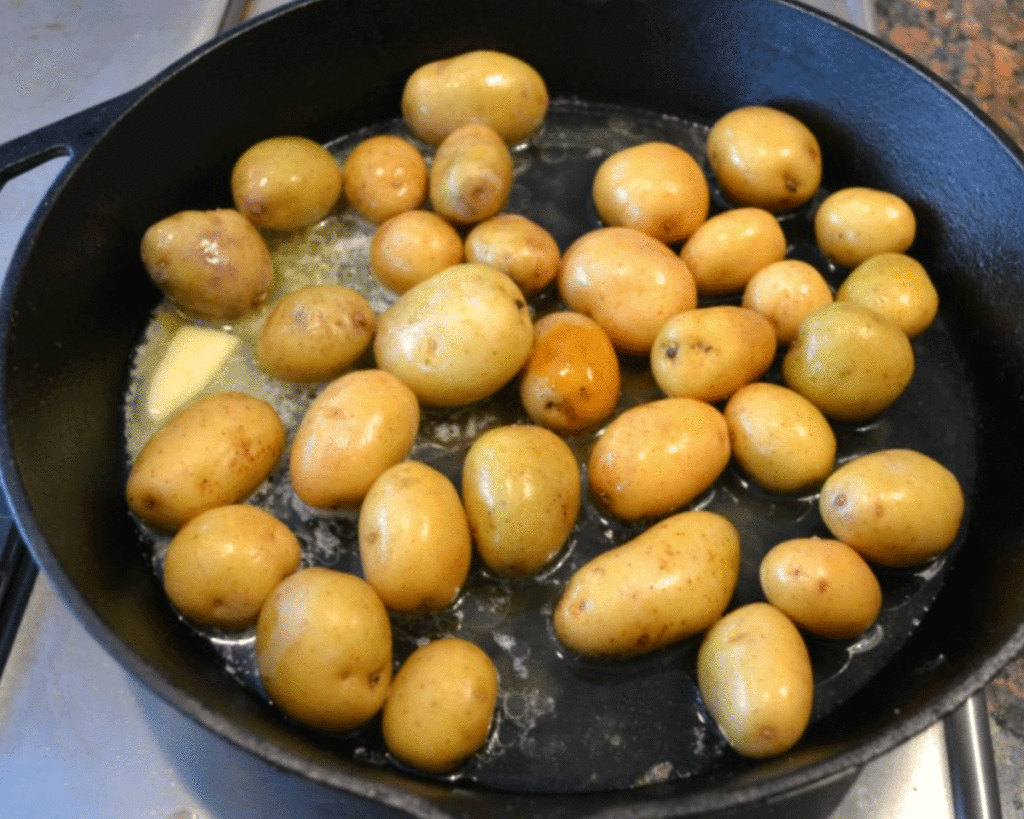 Potatoes roasting in a black cast iron skillet