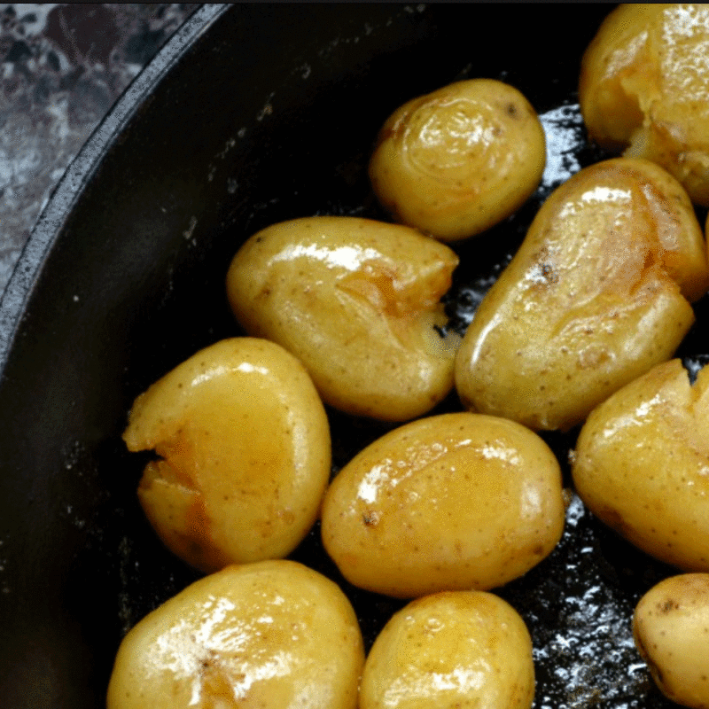 Roasted potatoes with olive oil in a black cast iron skillet