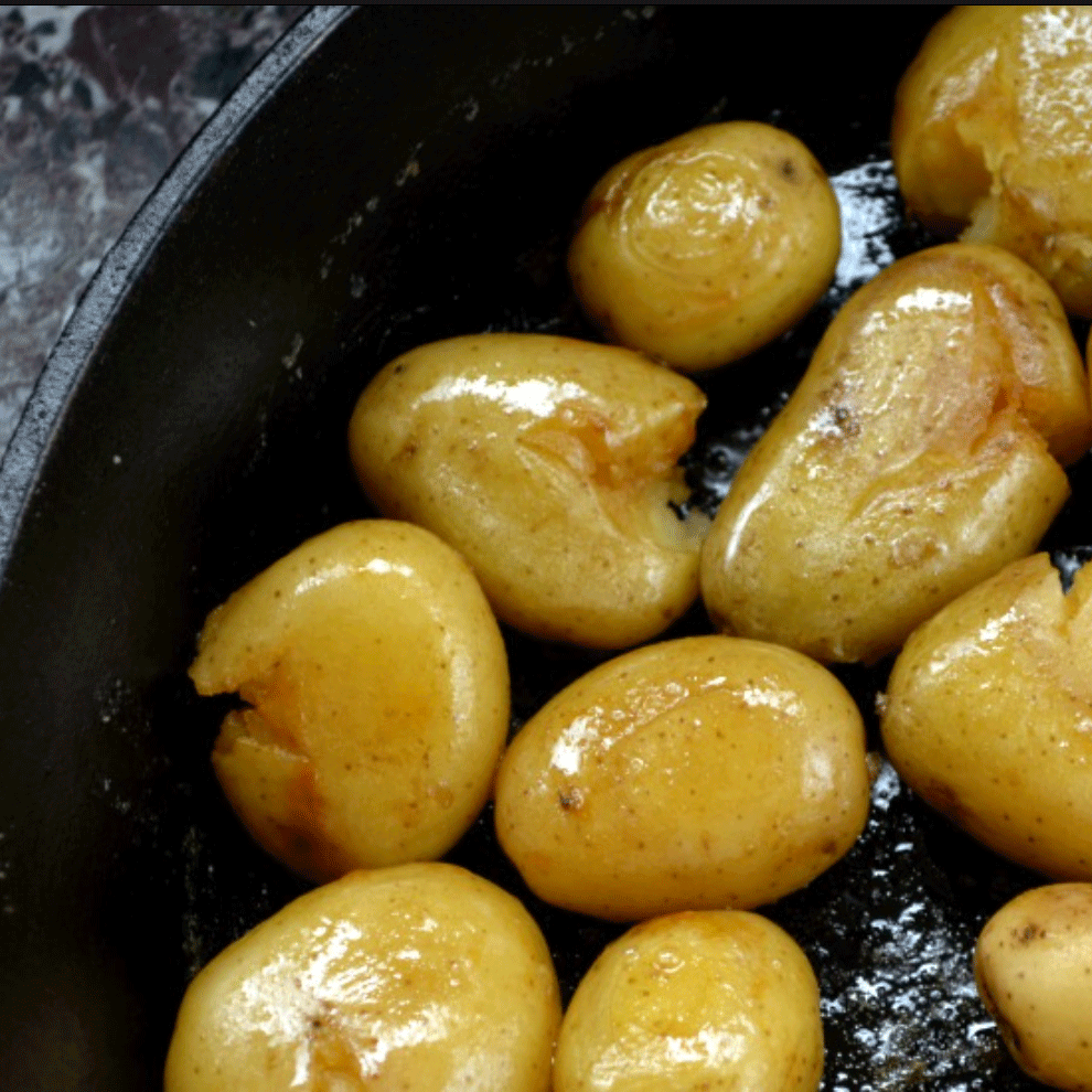 Roasted potatoes with olive oil in a black cast iron skillet