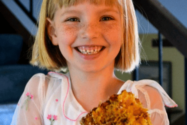 Girl holding slice of carrot cake on a plate