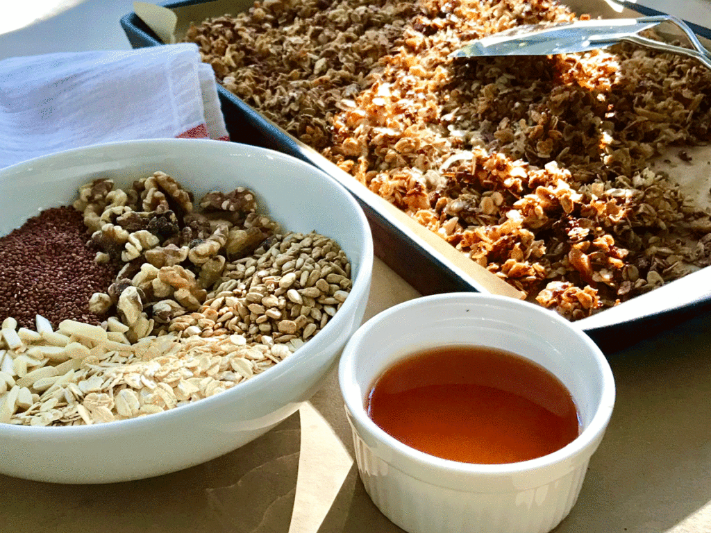Bowls of grains and nuts and honey for homemade granola