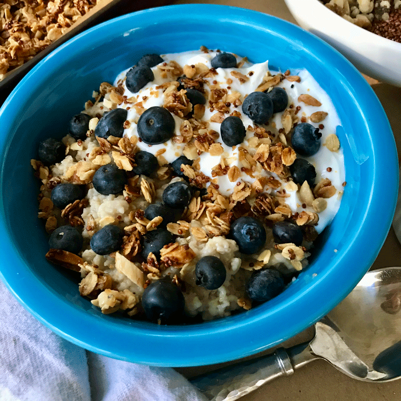 Blue bowl filled with oatmeal, yogurt, blueberries and granola