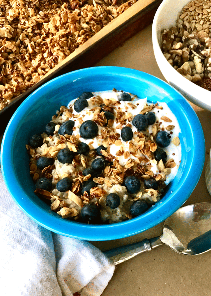 Bowl of oatmeal with granola, yogurt and blueberries.