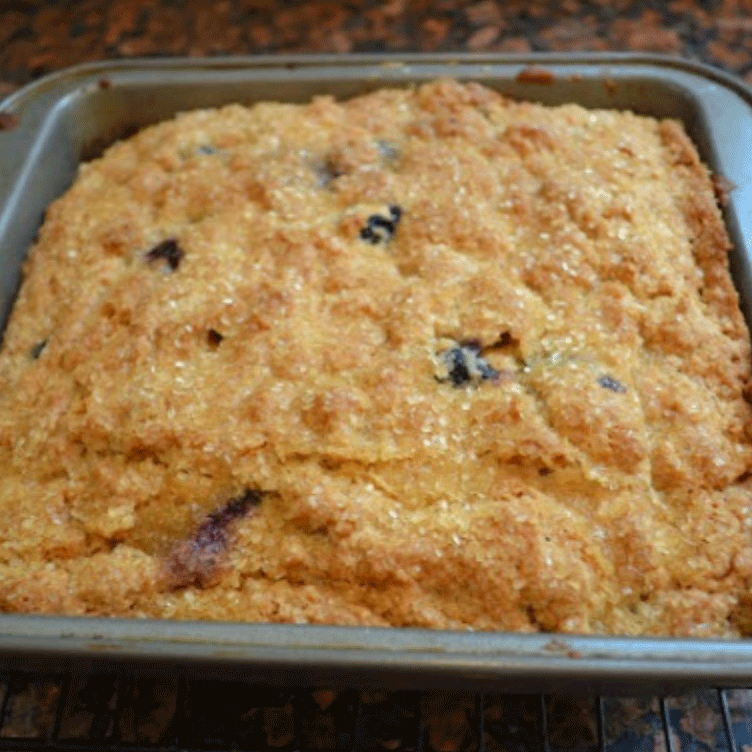 A square pan filled with blueberry buttermilk coffee cake