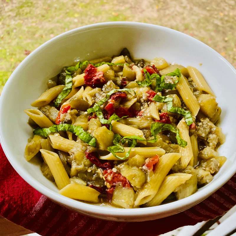 A bowl of pasta with sauteed eggplant and tomatoes
