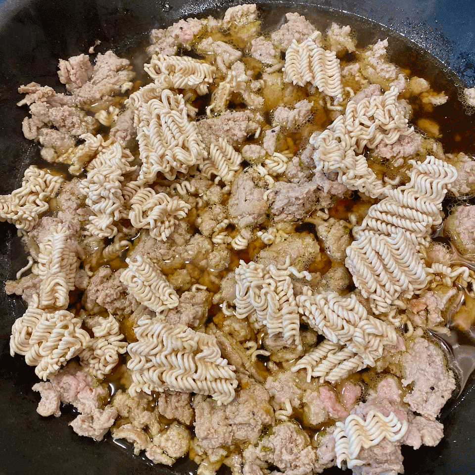 Ground turkey with broken ramen noodles in askillet