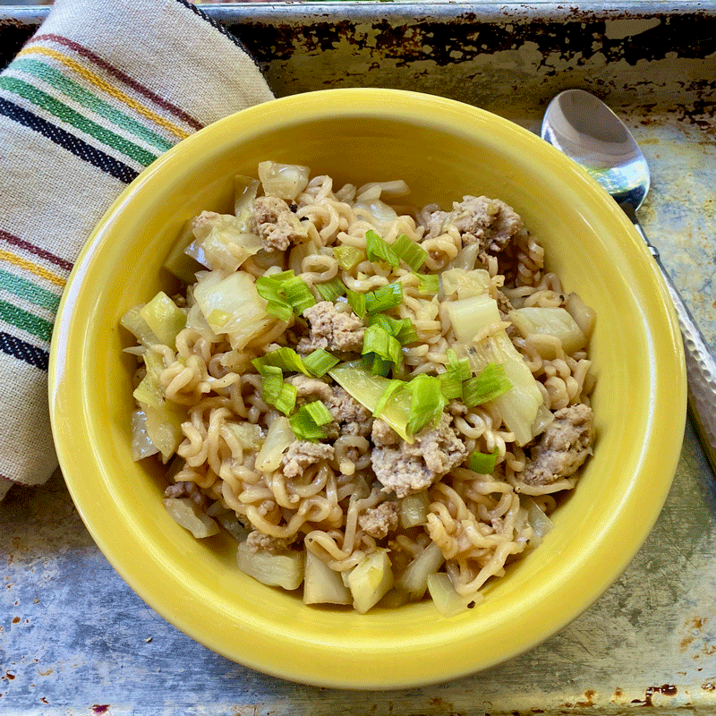 A yellow bowl with ramen noodles, ground turkey and cabbage