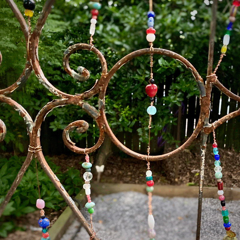 Closeup of glass bead strings in a metal garden trellis