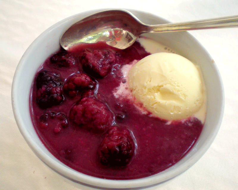 Blackberry doobie with a scoop of lemon ice cream in a bowl with a spoon