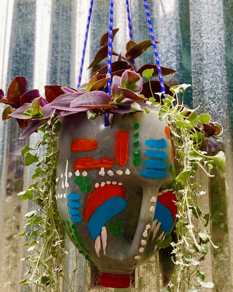 Painted hanging basket planter in a garden