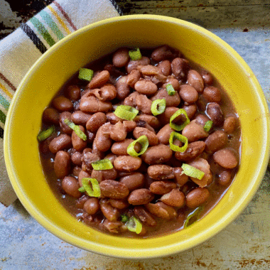 Pinto beans with green onions in a yellow bowl